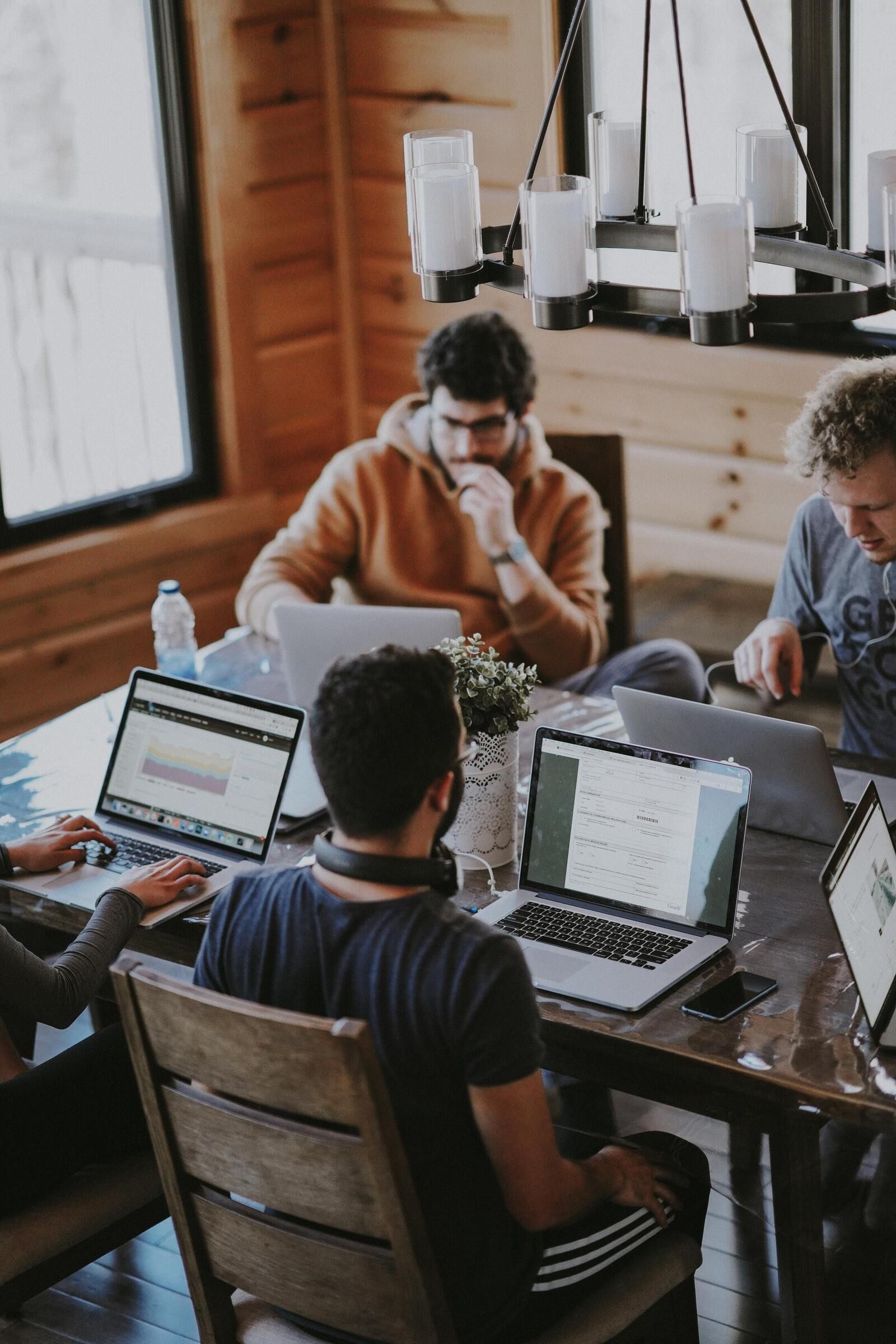 Diverse groep medewerkers zit samen aan tafel by Annie Spratt on Unsplash